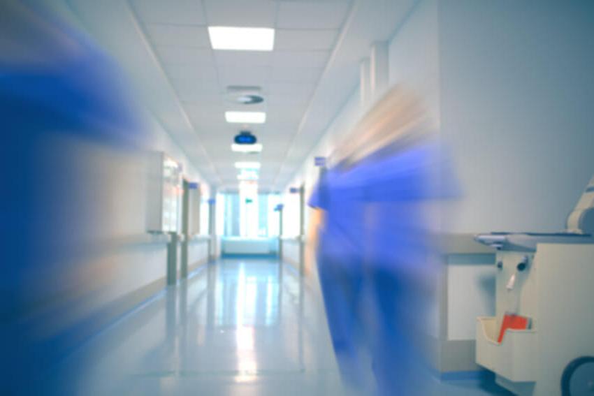 Blurred health workers walking down a hospital corridor