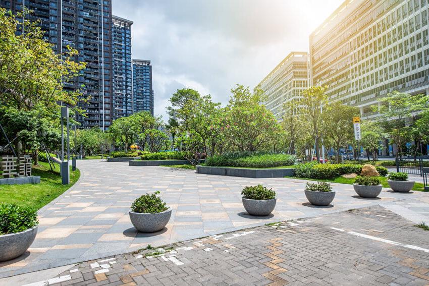 Buildings with greenery and seating area in between